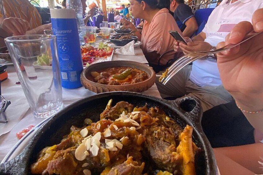 A meal with a variety of dishes, a water bottle, and a person using a smartphone. 3