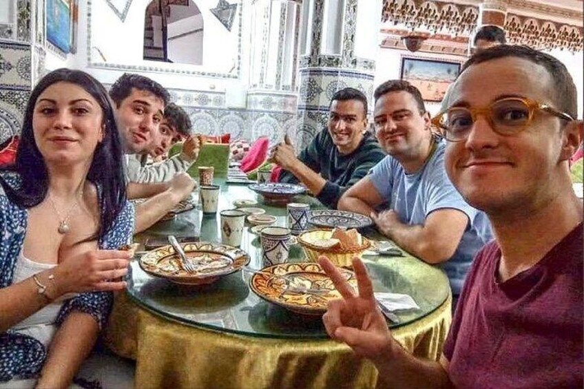 A group of people dining at a table with various dishes. 5
