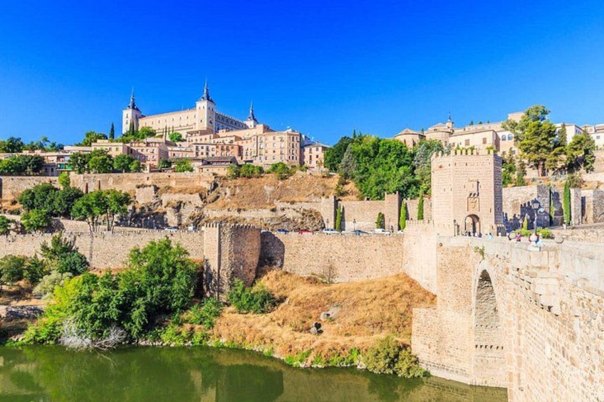 A historic cityscape with a prominent castle, a river, and a bridge. 4