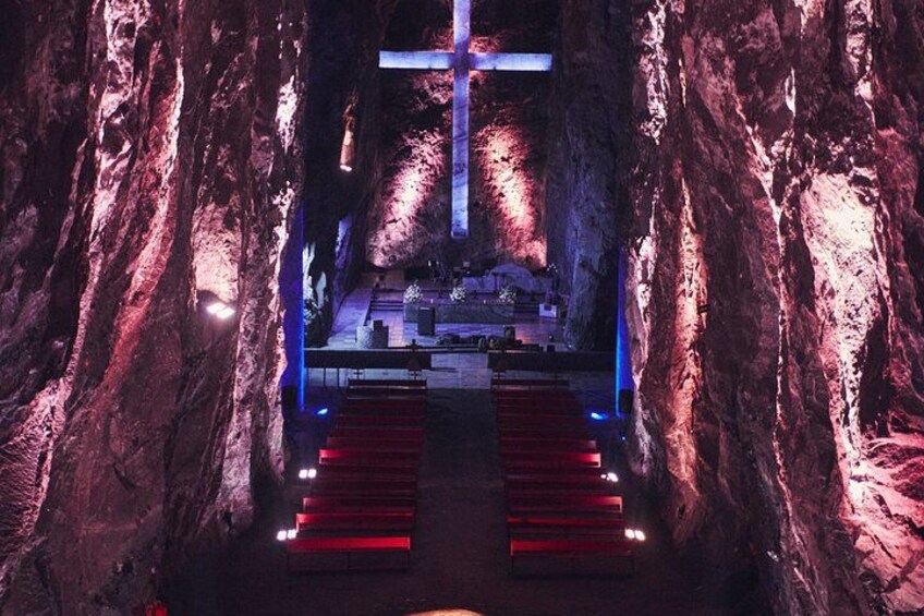 A cave with a cross, red steps, and a platform with lights. 3
