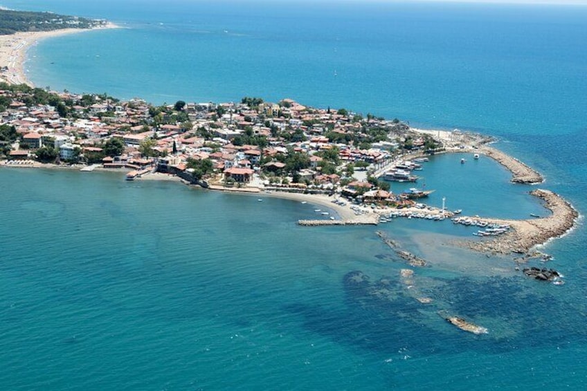 A coastal town with buildings, a beach, and boats. 3