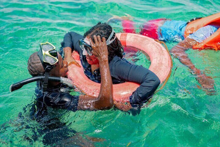 Två personer som snorklar i en pool med klart vatten. 3