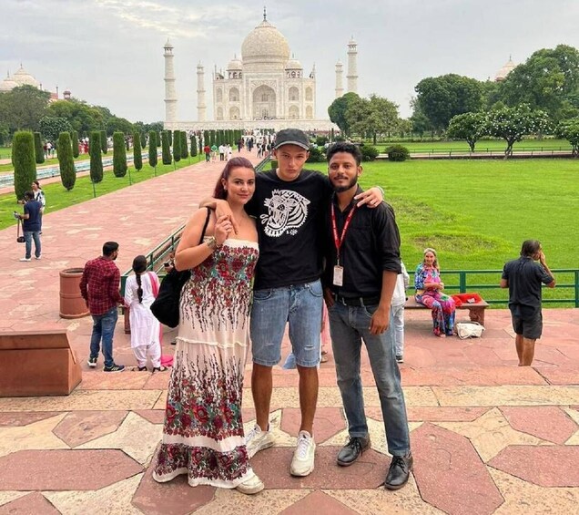 A group of people posing in front of the Taj Mahal. 1
