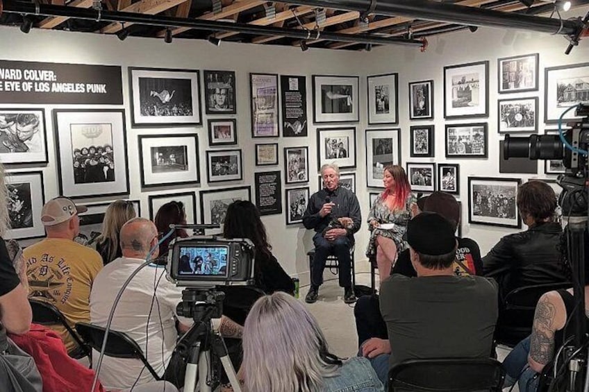 A panel discussion with a man and a woman in the center, surrounded by seated audience members. 4