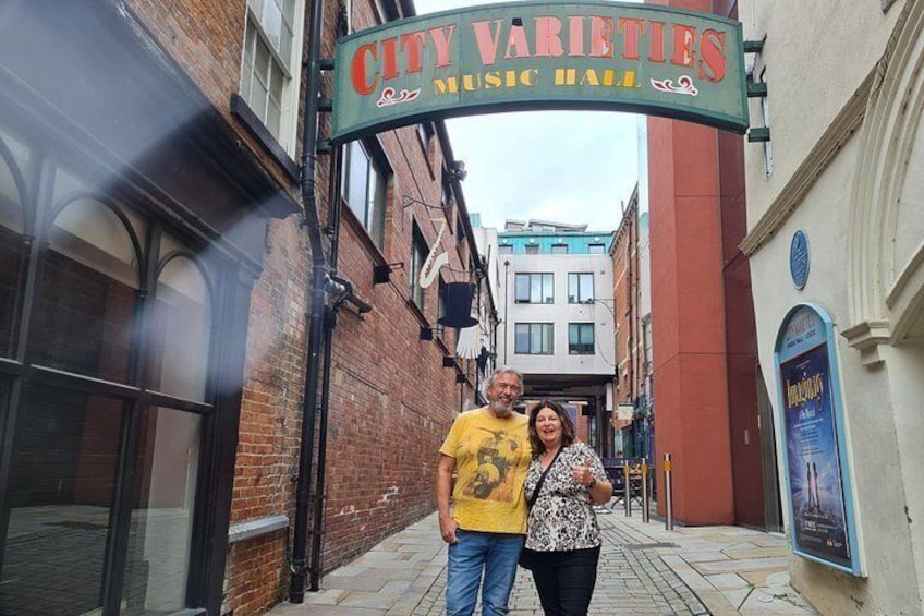 A couple standing in front of the City Varieties Music Hall sign. 2