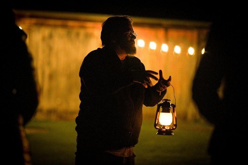 A person holding a lantern in a dimly lit outdoor setting. 3