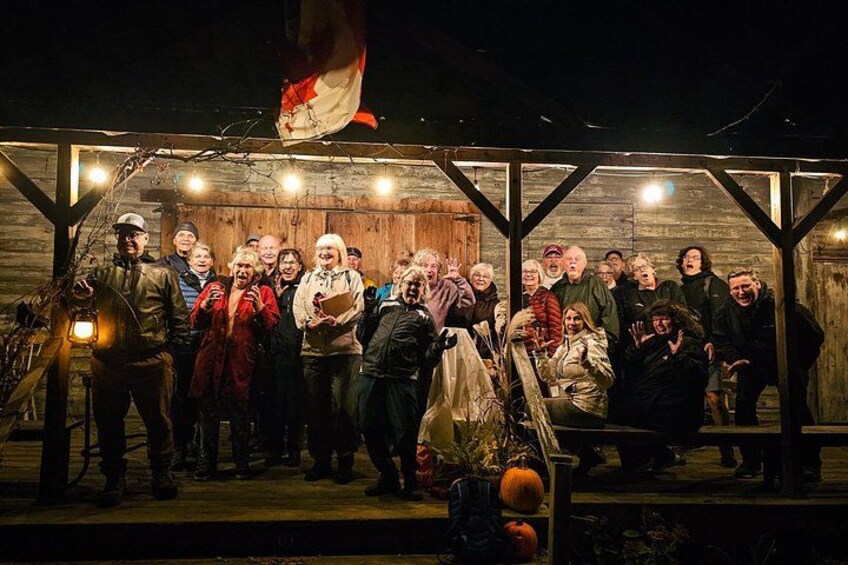 A group of people gathered under a wooden structure at night. 5