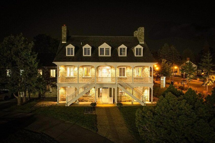 A large, illuminated house with multiple windows and a front porch. 4