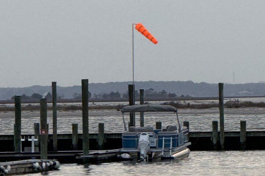 A boat docked at a pier with an orange buoy in the water. 2