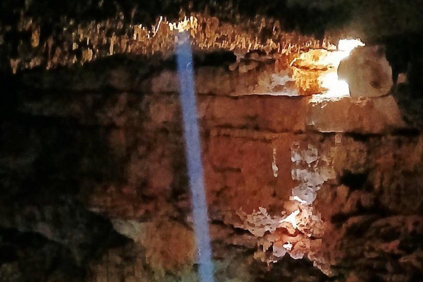 A cave interior with rock formations and a narrow passageway. 2