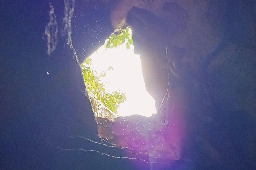 A cave entrance with a small opening allowing light to enter. 4
