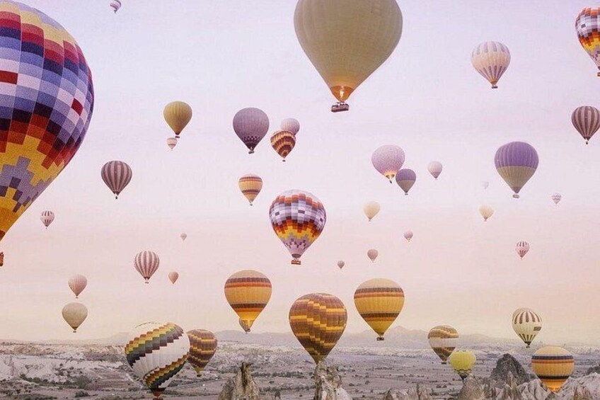 A landscape with multiple hot air balloons in various colors and patterns. 3