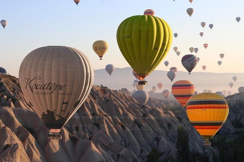 Hot air balloons over rocky terrain. 1