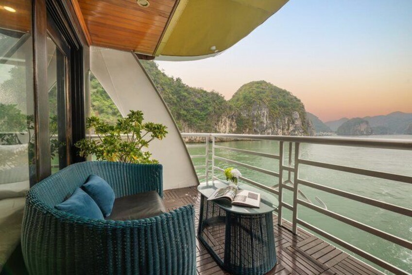 A balcony with wicker furniture, a small table, and a potted plant. 3