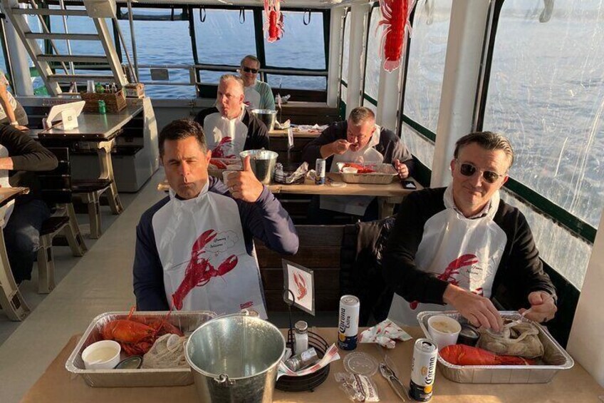 People dining on a boat with lobster and seafood. 1