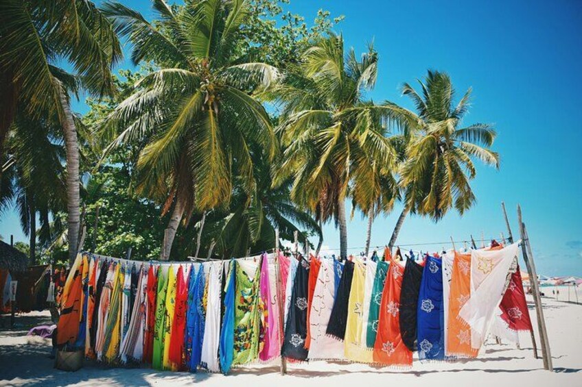 Ein Strand mit einer Reihe bunter Flaggen, die zwischen Palmen hängt. 2