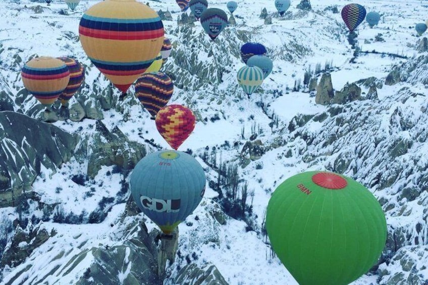 A snowy landscape with colorful hot air balloons. 2