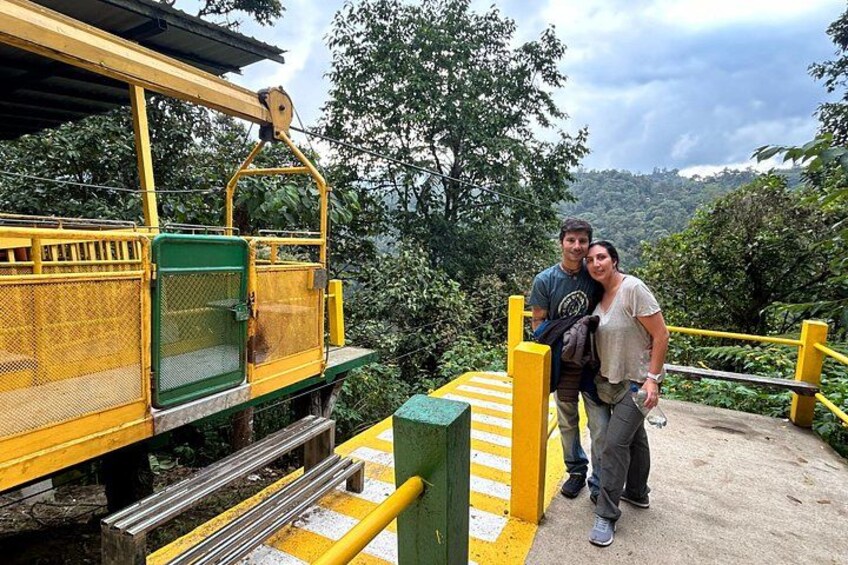 A yellow and green cable car system with passengers. 3