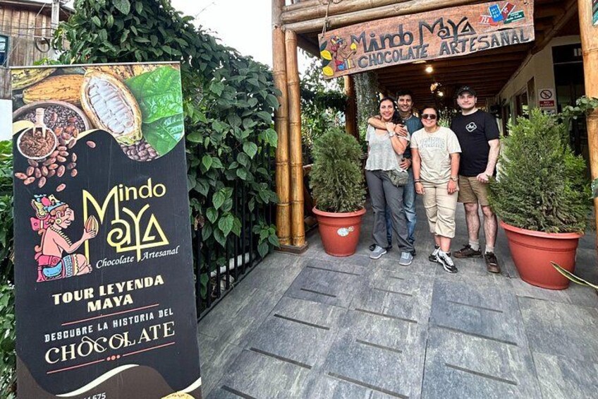A group of people standing in front of a building with a sign that reads 'Mindo Maya Chocolate Artesanal.' 2