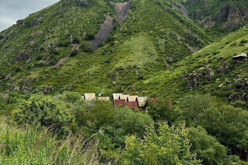 A mountainous landscape with a red-roofed building surrounded by lush greenery. 3