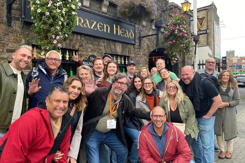 En gruppe mennesker poserer foran en pub ved navn 'Razen Head'. 4