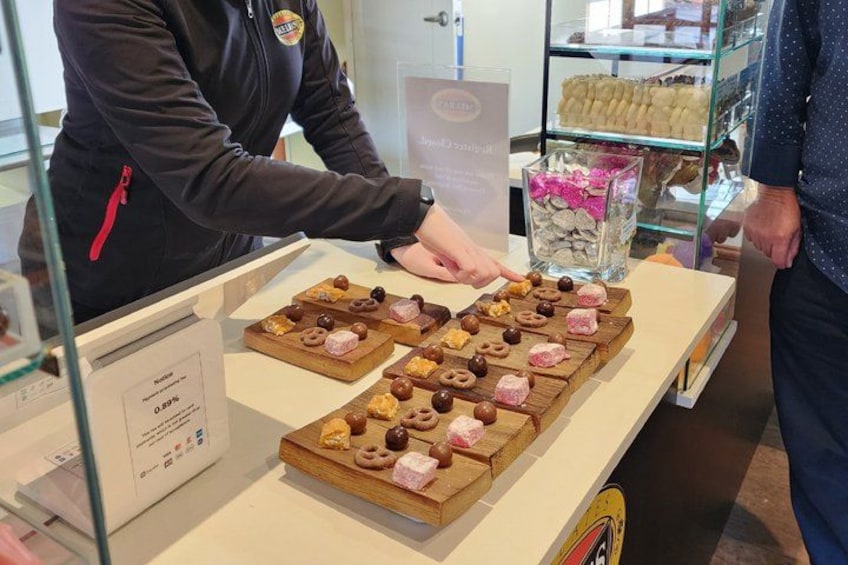 A person arranging pastries on a display counter in a bakery. 3