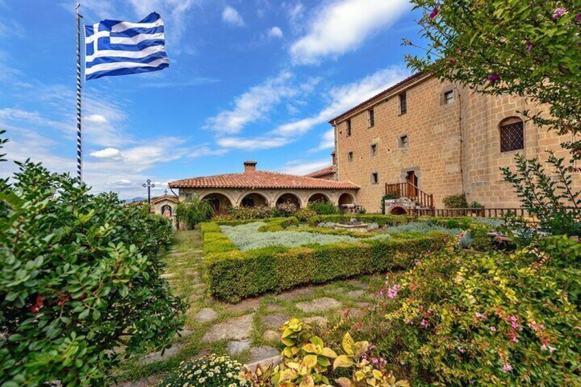 A building with a flag, a garden, and a clear sky. 4
