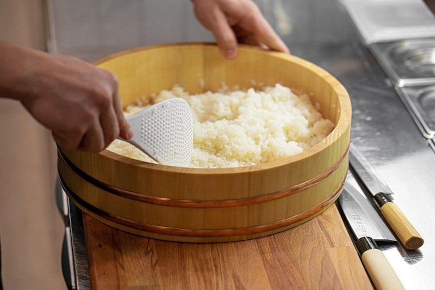 A person grating cheese into a wooden bowl. 2
