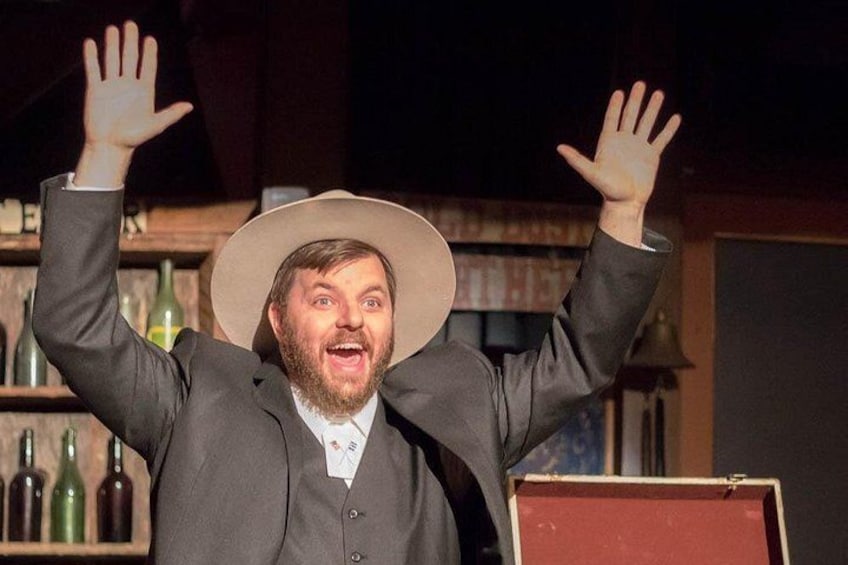 A person in a suit and hat with raised hands. 3
