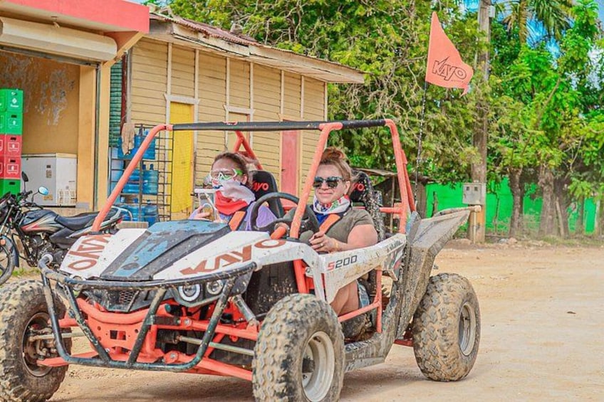 A red and white ATV with the number 200 parked in front of a building. 1