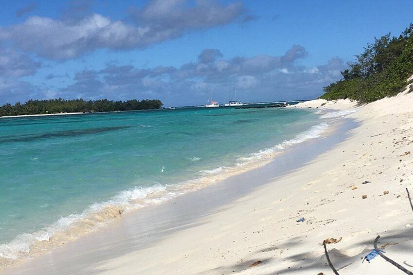 A beach with clear turquoise water, white sand, and a distant island. 2