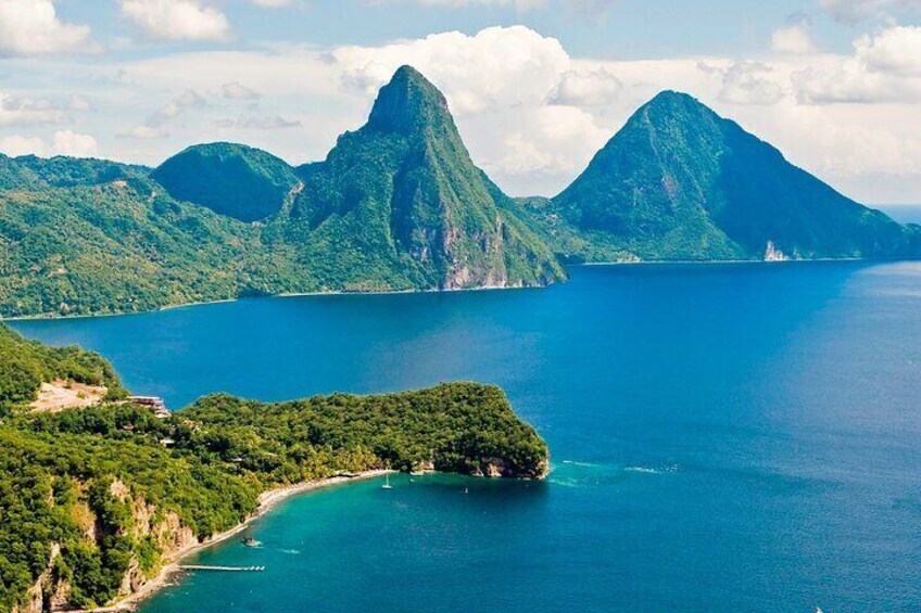 A coastal landscape with a prominent mountain, a small island, and a clear blue sea. 3