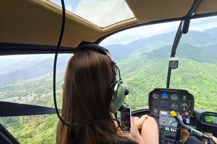 Una persona nell'abitacolo di un elicottero con vista su un paesaggio montuoso. 1