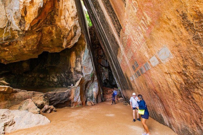 A cave with a narrow passageway and large rock formations. 4
