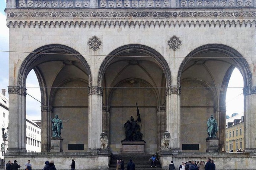 A large stone archway with statues and a central relief sculpture. 4