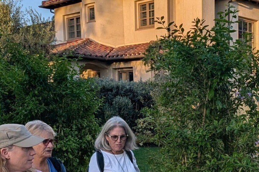 Ein Gebäude mit rotem Ziegeldach, umgeben von üppigem Grün und einem gepflegten Garten. 1