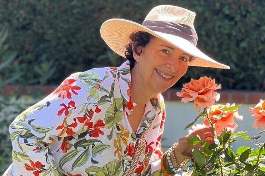 Eine Person mit Blumenhemd und Hut, die eine Pflanze hält. 4