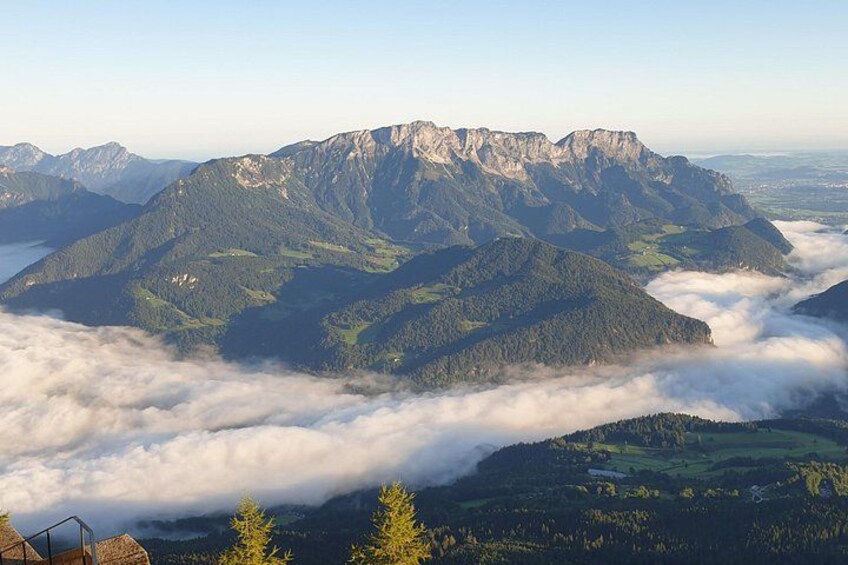 A mountain range with a valley below, surrounded by clouds. 2