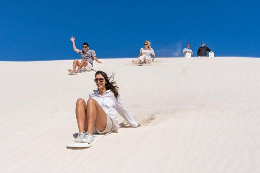 People sliding down a sand dune. 3