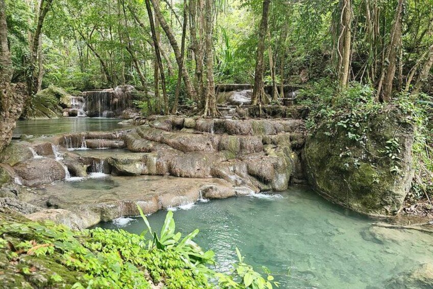 A clear, natural water stream with rocky formations and lush greenery. 2