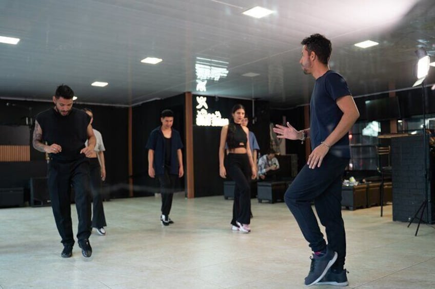 Une séance de répétition de danse dans un studio moderne avec un mur de verre et des éléments décoratifs en bois. 3