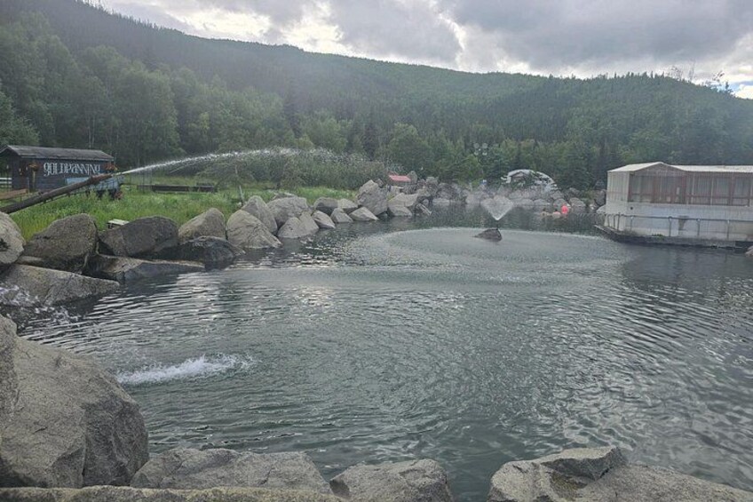Une rivière avec des rochers, un bateau et un bâtiment dans une région montagneuse. 4