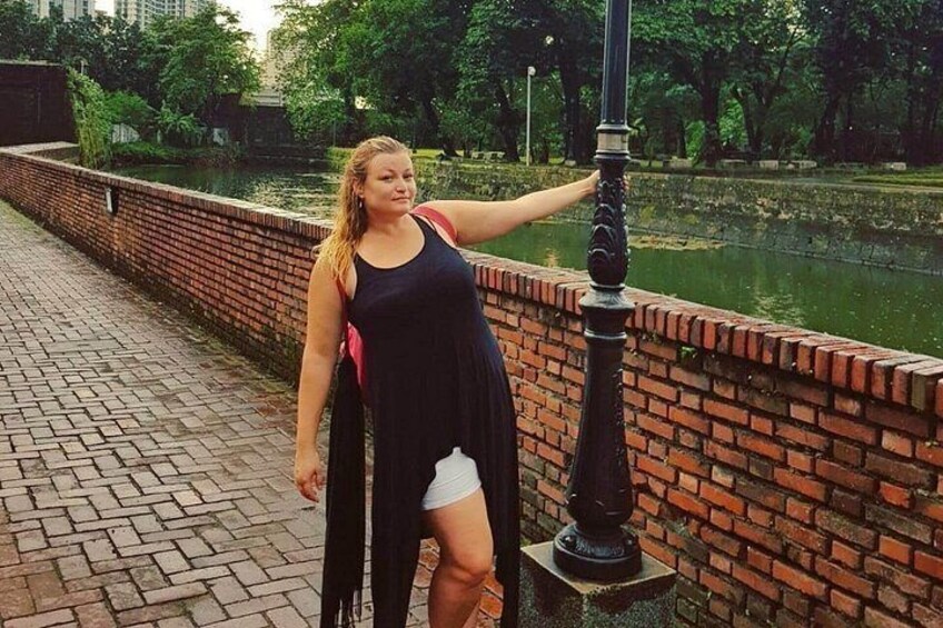 A person standing by a brick wall with a water body in the background. 5