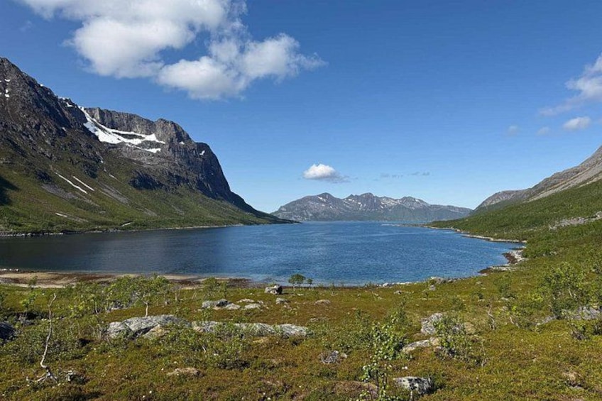 Un lago rodeado de montañas, con un cielo despejado y algunas nubes. 1