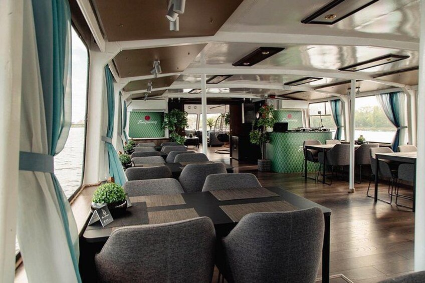 A dining area with tables and chairs on a boat. 4