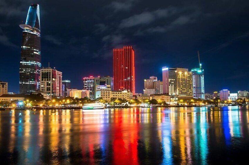 Lo skyline di una città di notte, con edifici illuminati che si riflettono sull'acqua. 2