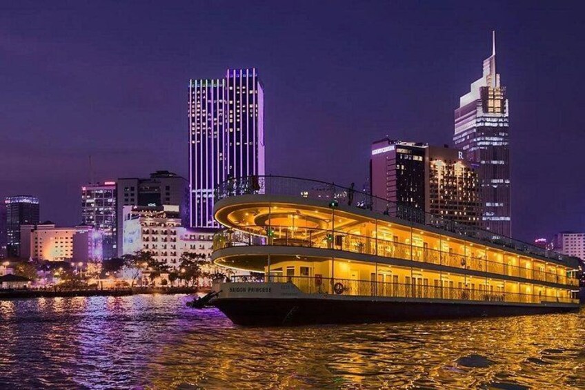 A river with a brightly lit boat and a city skyline in the background. 4