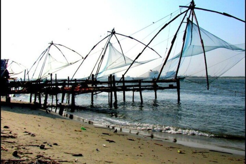 A beach with fishing nets and a wooden pier extending into the water. 2