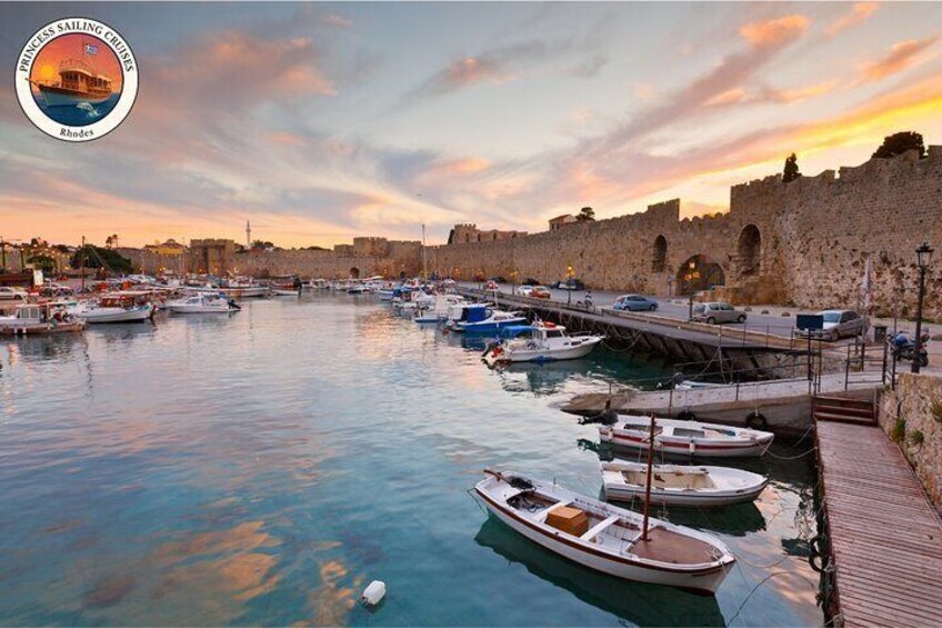 A harbor with boats docked, a wooden walkway, and a stone wall in the background. 5