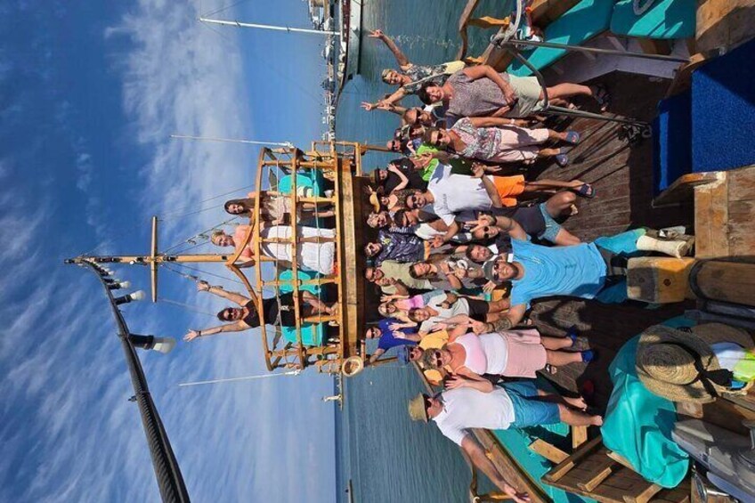 A group of people on a wooden boat docked at a pier. 3